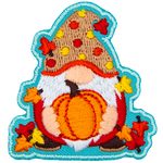 A gnome holds a ripe pumpkin. The gnome is covered in leaves and wears a red and yellow polka-dotted hat.