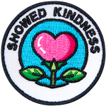 A pink flower in the shape of a heart under the words Showed Kindness. 