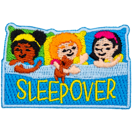 Three little girls are pretending to be asleep in bed. The word Sleepover is across the blanket.