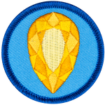 A golden citrine is in the centre of a circular blue badge.
