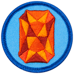 An orange sapphire is in the centre of a circular blue badge.