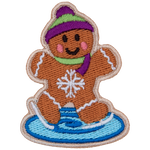 A gingerbread person skates on ice with a pink and green hat and scarf.