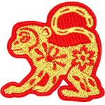 A gold monkey with a red outline and floral details on its body.