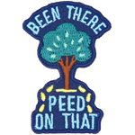 A tree sits between the words Been There Peed On That with little yellow droplets coming out of it.