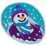 A smiling snowperson in mitts and a toque tubes down a hill in a purple tube.