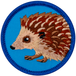 A brown hedgehog is on a blue patch.