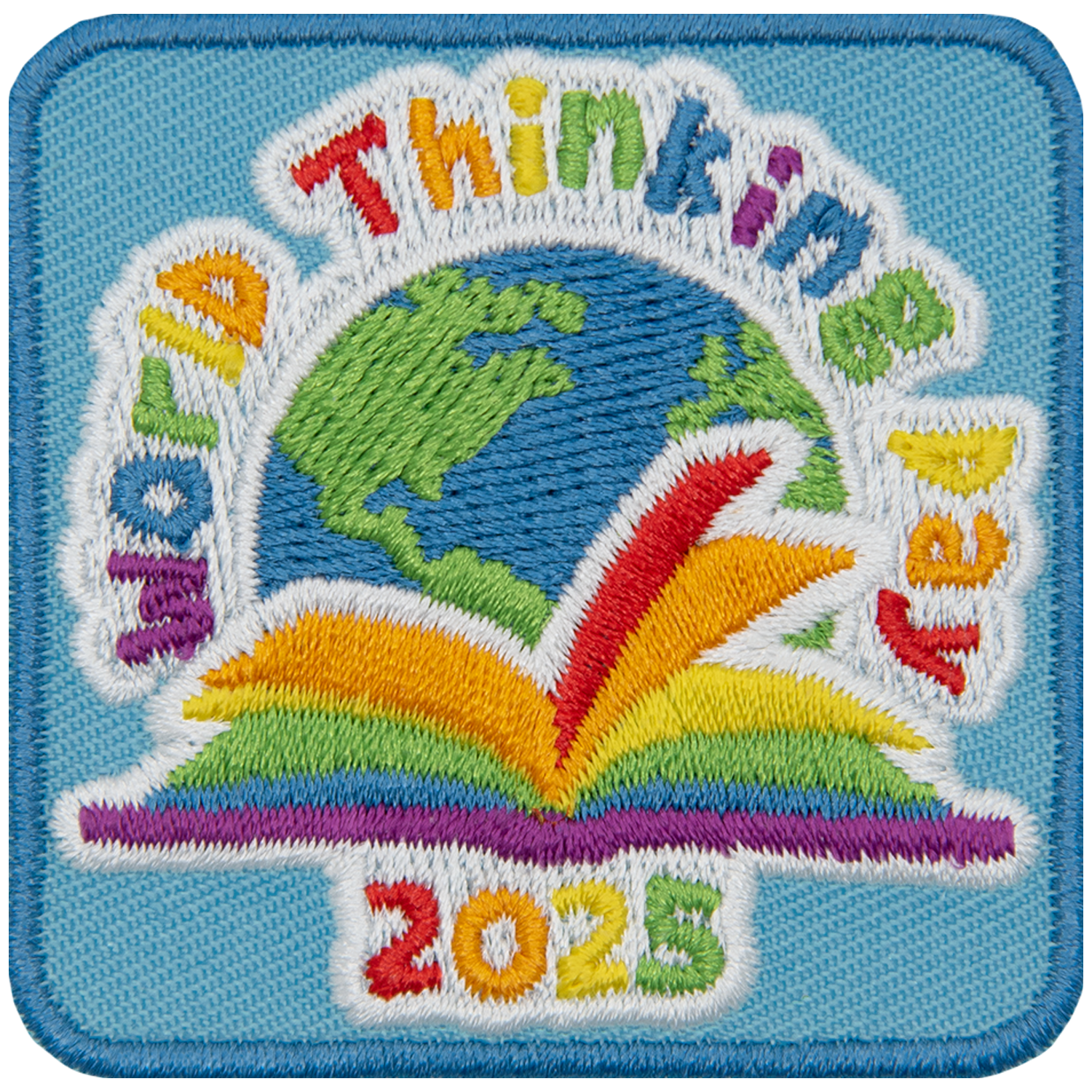 A rainbow book sitting in front of a globe under the words World Thinking Day.
