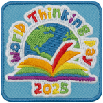A rainbow book sitting in front of a globe under the words World Thinking Day.