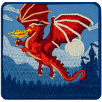 A red dragon blows fire midflight with a castle in the background.