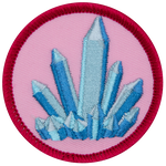 A blue, pointed crystal sits on a soft pink background.