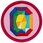A rainbow gemstone on a pink background.
