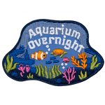 A fish and a sea turtle swim through a coral reef under the words Aquarium Overnight.