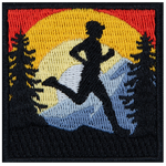 A figure running in a forest, in front of a sunset.