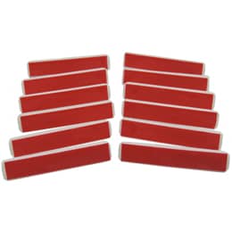 A pile of pin-backs rests in the center of this photo. Below the pile are two pin backs, one showing the adhesive side and the other displaying an open pin.