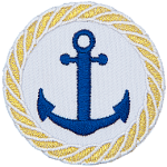 A two pronged, barbed nautical anchor is in the center of this circular crest. A braided rope made of gold thread is embroidered around the edge as a border.