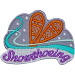A pair of wooden snowshoes are on a background of snow and wind. The word Snowshoeing is embroidered across the bottom.
