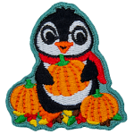 A cute penguin in a red scarf holding an orange pumpkin.