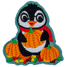 A cute penguin in a red scarf holding an orange pumpkin.