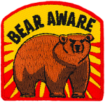 A bear stands threateningly under the words Bear Aware.