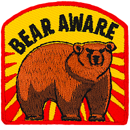 A bear stands threateningly under the words Bear Aware.