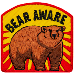 A bear stands threateningly under the words Bear Aware.