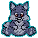 An adorable wolf pup sits on its bottom and smiles at the viewer with big brown eyes.