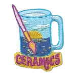 A glass painted with a sunset above the words Ceramics.