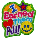 The words I Earned Them All dominate this patch. In the bottom right sits a yellow smiley face, and in the top right are two stars. 