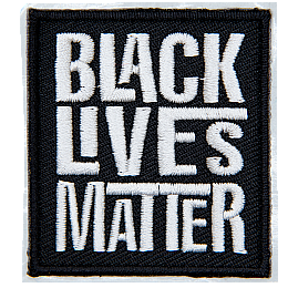 A black rectangle has the words Black Lives Matter embroidered in grey thread. Each word is stacked on top of the next.