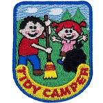 A boy and a girl work together to clean up their campsite and show that they are tidy campers.