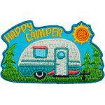 The words Happy Camper are in the sky above a camper on a sunny day.