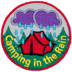 Dark clouds pour rain down on a tent in the woods during a night of camping in the rain.