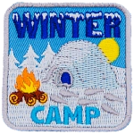 An igloo sits next to a campfire in a field of snow, symbolizing a winter camp.