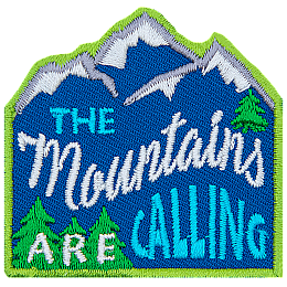 The words The Mountains Are Calling are stitched across a mountain range with pine trees.