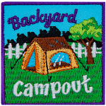 A brown tent is in a backyard in front of a white fence. The words Backyard Campout are above and below it.