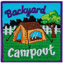 A brown tent is in a backyard in front of a white fence. The words Backyard Campout are above and below it.