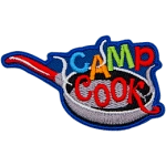 The words Camp Cook are being fried in a frying pan.