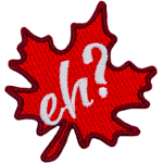 A red maple leaf sits at a fifteen-degree angle. The word Eh? is embroidered in white in the leaf's center.