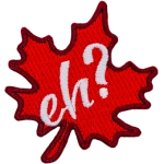 A red maple leaf sits at a fifteen-degree angle. The word Eh? is embroidered in white in the leaf's center.