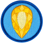 A golden citrine is in the centre of a circular blue badge.