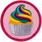 A rainbow-frosted cupcake on a pink background.
