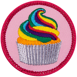 A rainbow-frosted cupcake on a pink background.