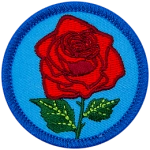A red rose is on a blue, circular patch.