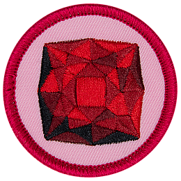 A red garnet is in the centre of a circular pink badge.