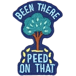 A tree sits between the words Been There Peed On That with little yellow droplets coming out of it.
