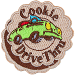 A green convertible car with the words Cookie Drive Thru stitched on a patch made to look like a layered cookie.