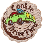A green convertible car with the words Cookie Drive Thru stitched on a patch made to look like a layered cookie.