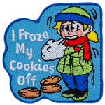 A young girl is bundled up in a hat, scarf, jacket, and thick pants as she stands shivering in the cold. Three cookies lie under the text I Froze My Cookies Off.