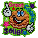 A flower-shaped cookie with frosting in the middle and big, cartoon eyes grins and points to the words Great Cookie Seller.