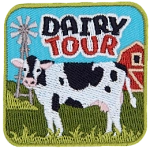 A black and white dairy cow faces the viewer underneath the words Dairy Tour.